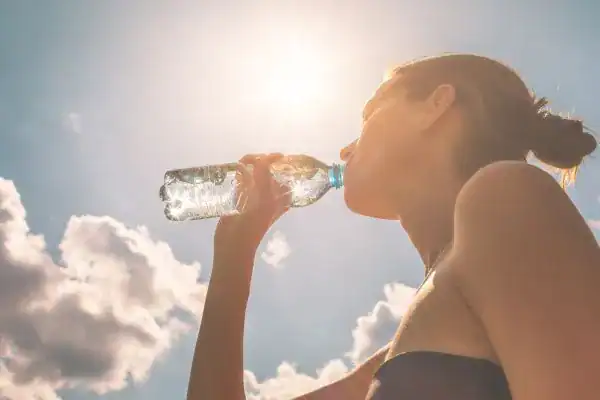 Hydration: The Secret Ingredient for a Toned Stomach and Enhanced Fitness 3 Image of woman drinking water to hydrate Borehamwood after run.